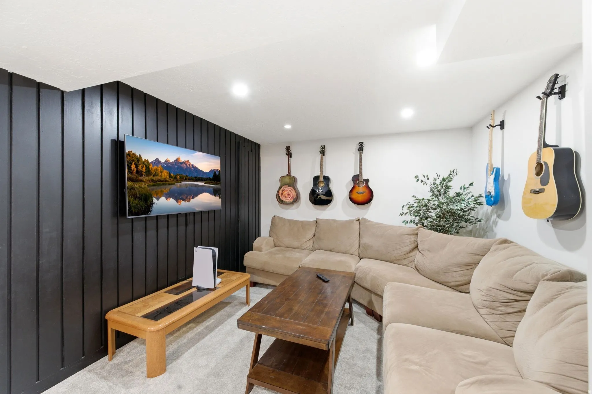 Living room with wooden walls, carpet flooring, and recessed lighting