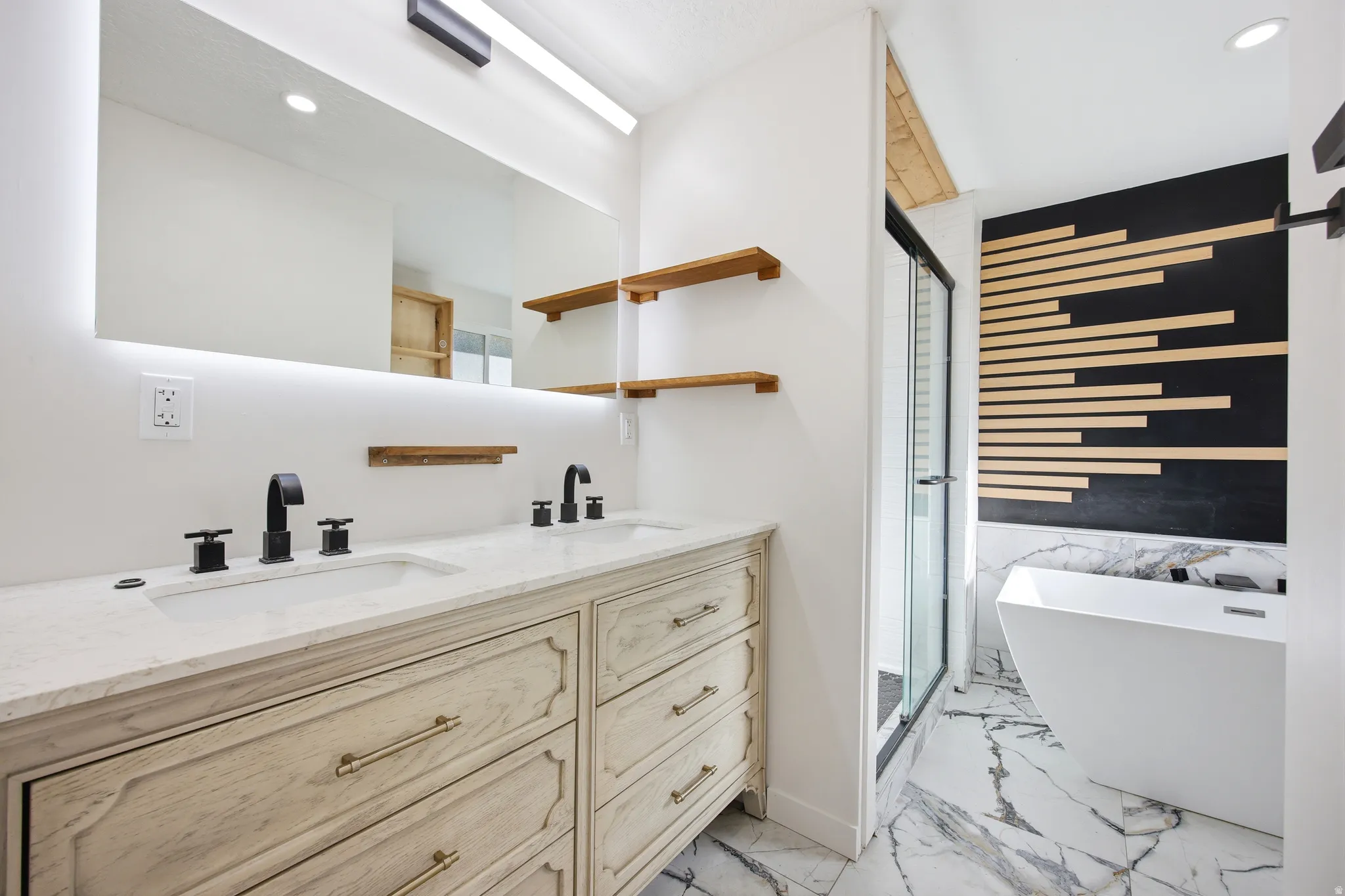 Bathroom featuring a double vanity with stone countertop, undermount sinks, and matte black fixtures