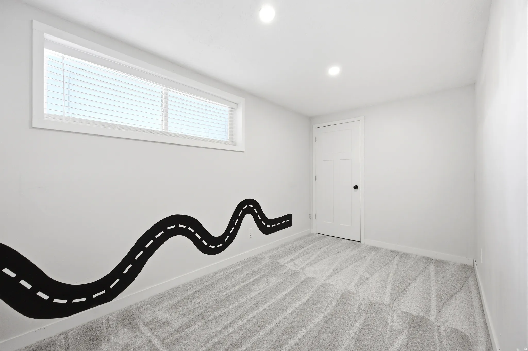 Room featuring a horizontal window with blinds, recessed lighting, and light gray carpet