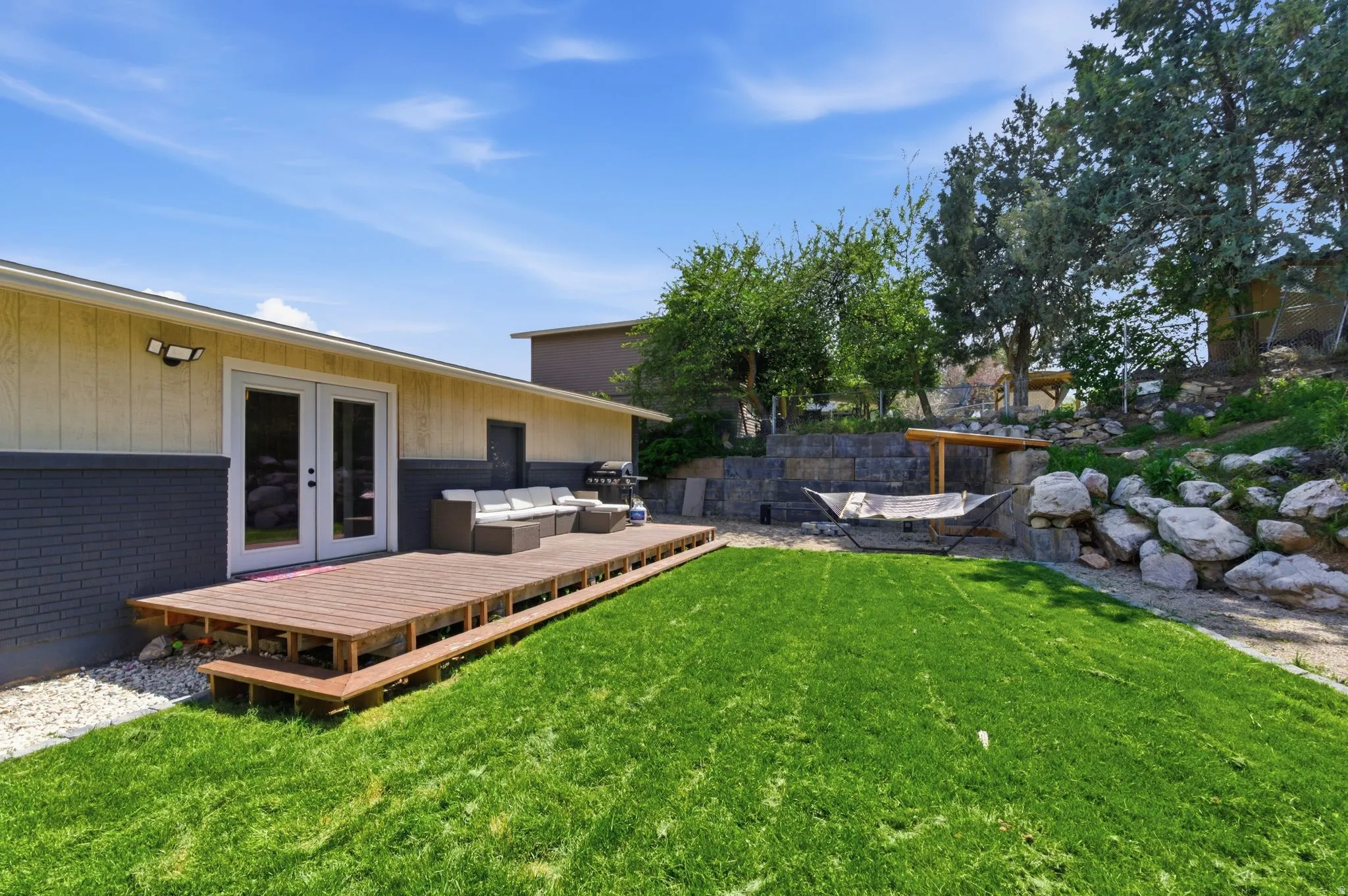 View of green lawn featuring french doors, an outdoor living space, and a deck