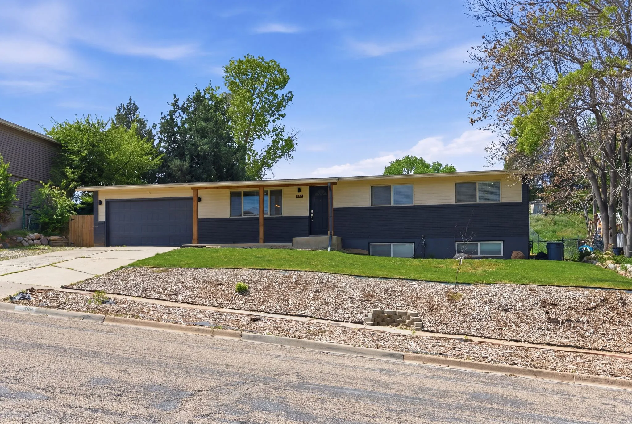 Ranch-style house featuring a front lawn, concrete driveway, and an attached garage