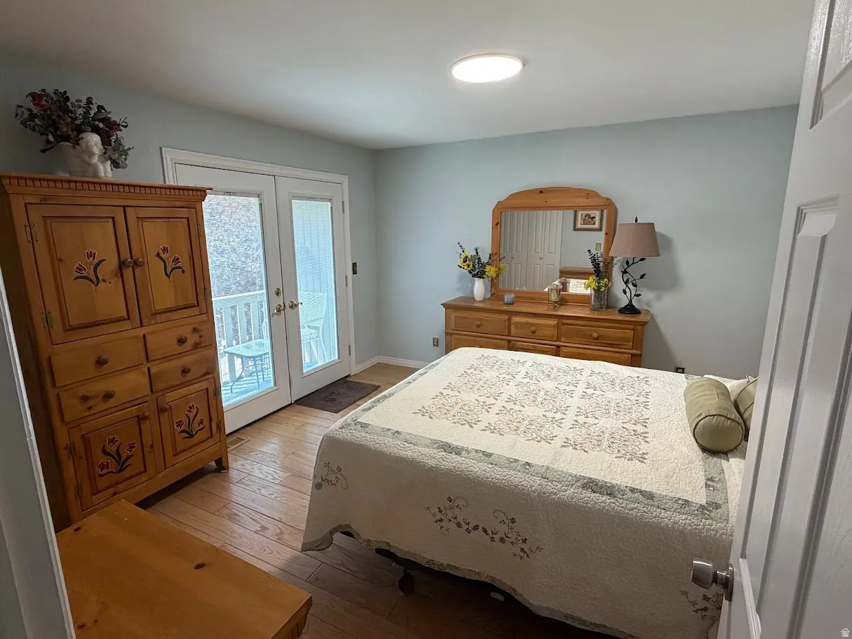 Bedroom with french doors, access to exterior, and hardwood / wood-style floors