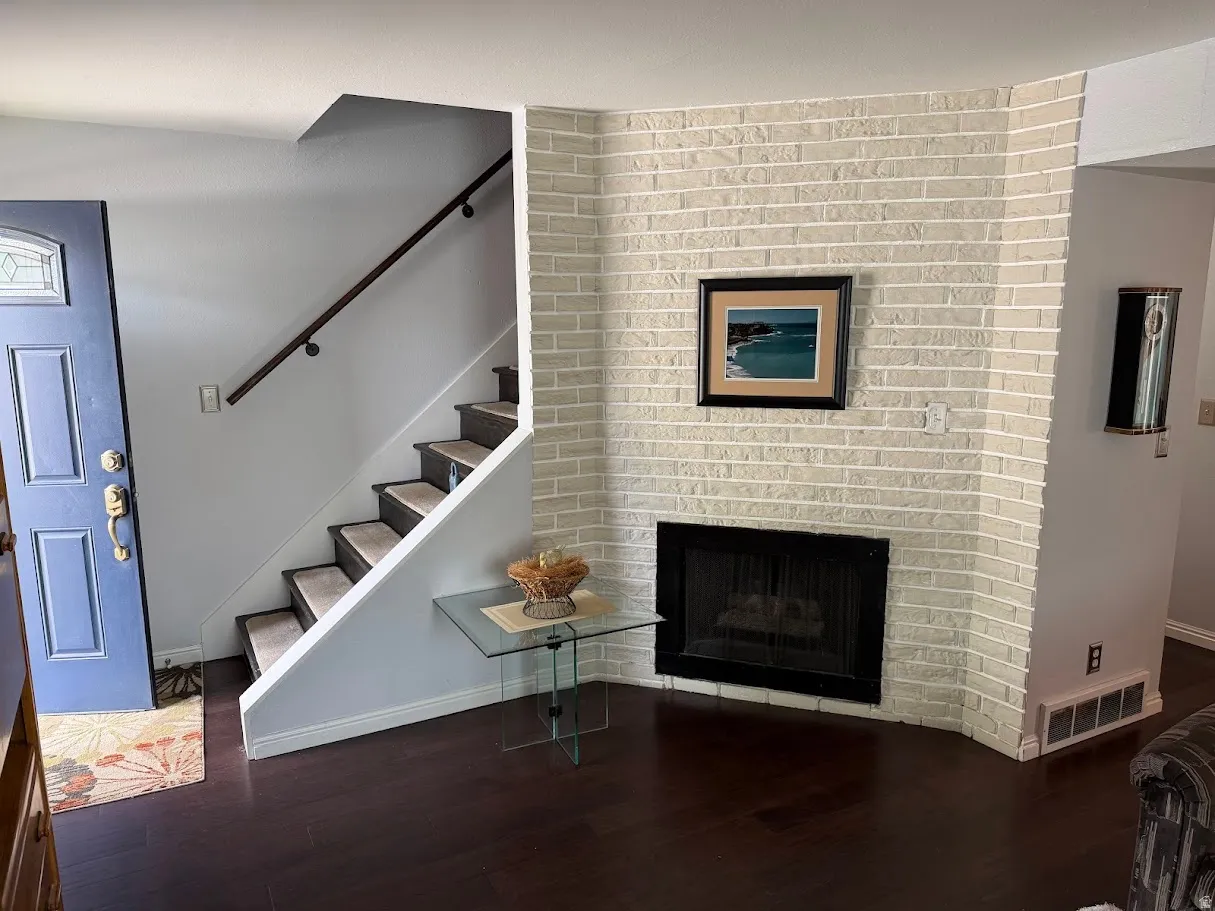 Living room featuring a fireplace and dark wood-style floors