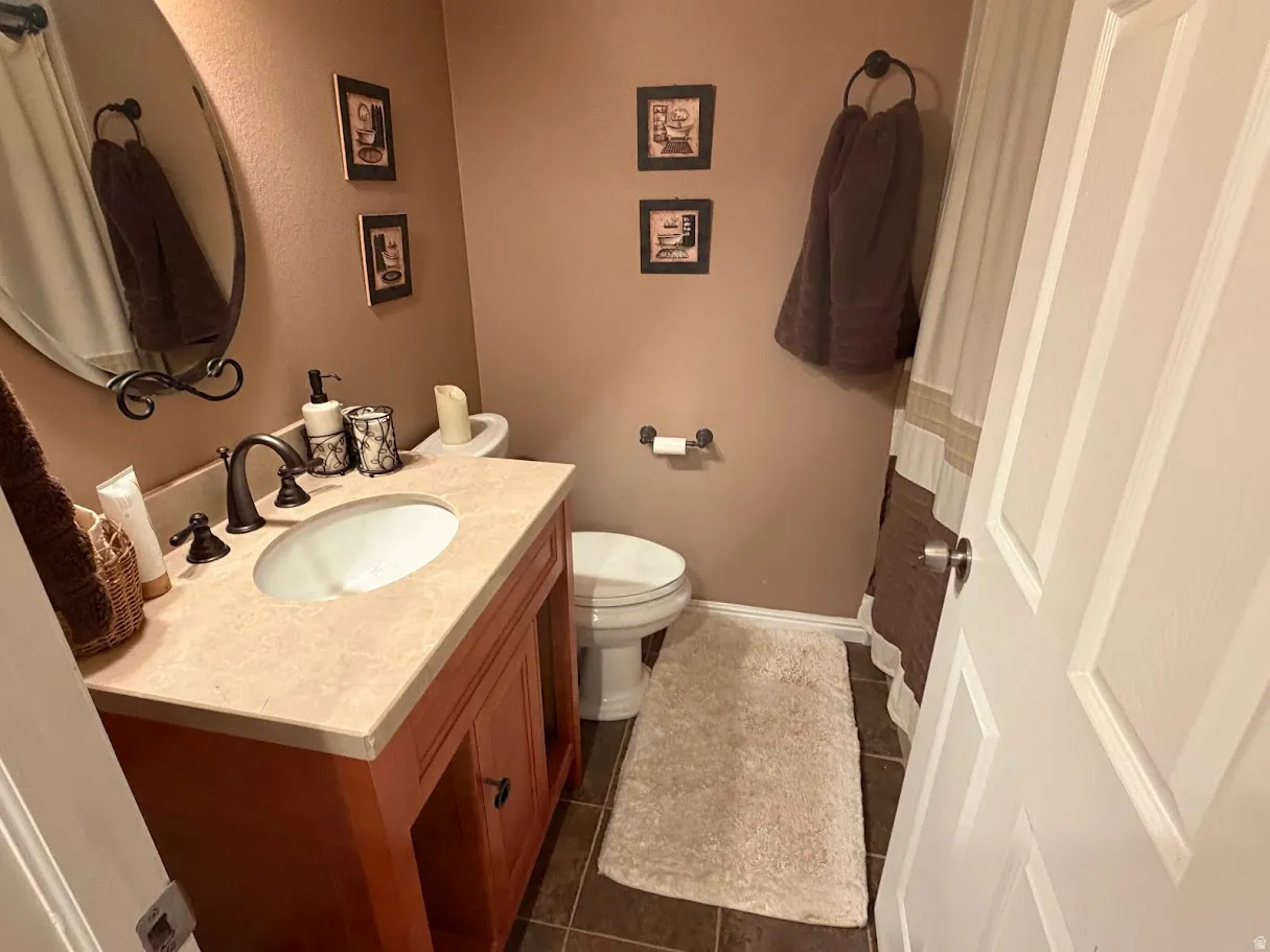 Bathroom with vanity and dark tile patterned flooring