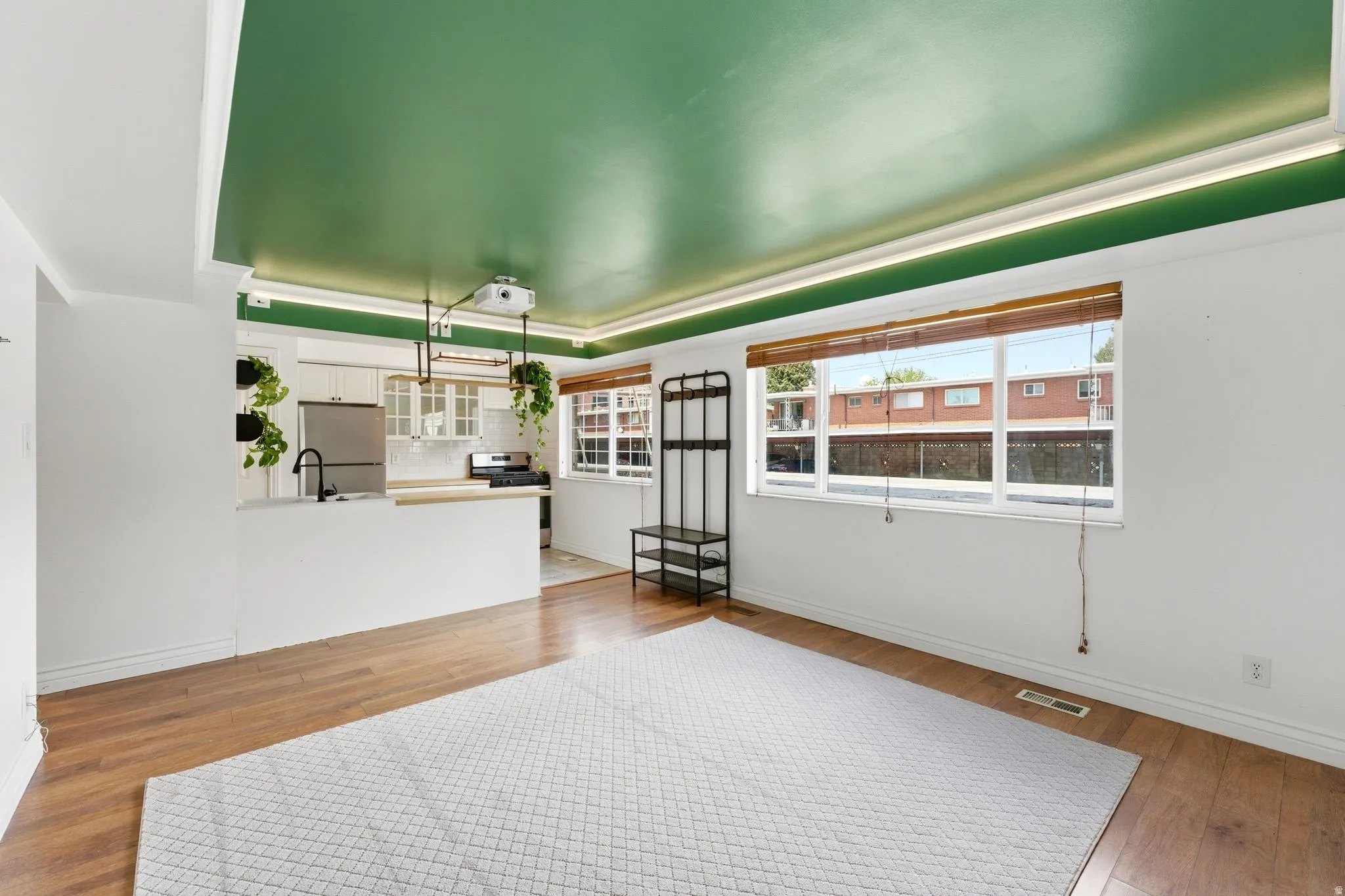 Living area with light wood-type flooring and a tray ceiling