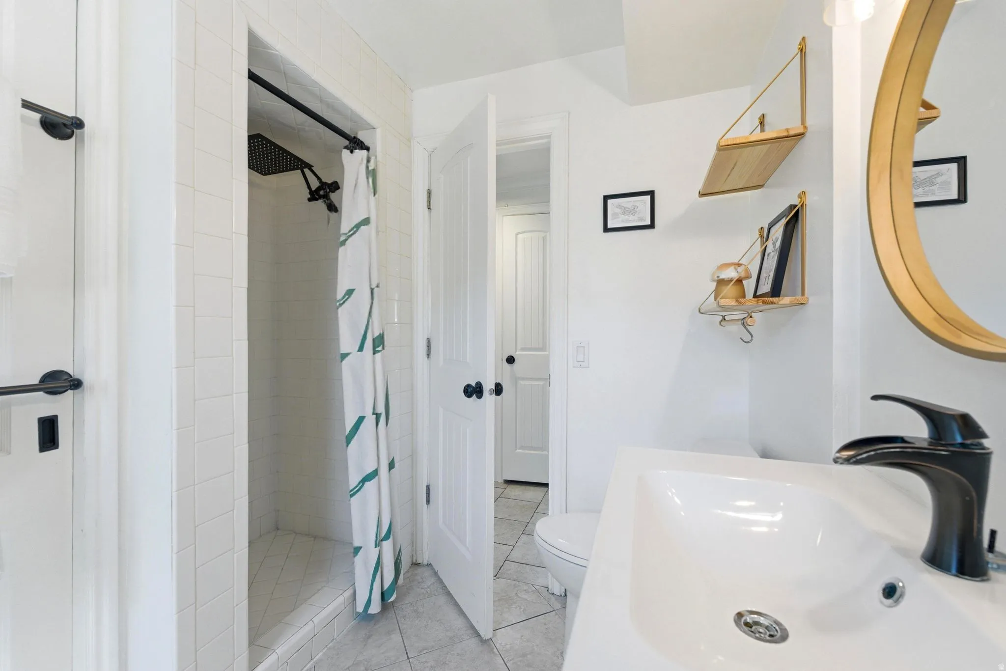 Bathroom featuring a shower stall, light tile patterned flooring, and vanity