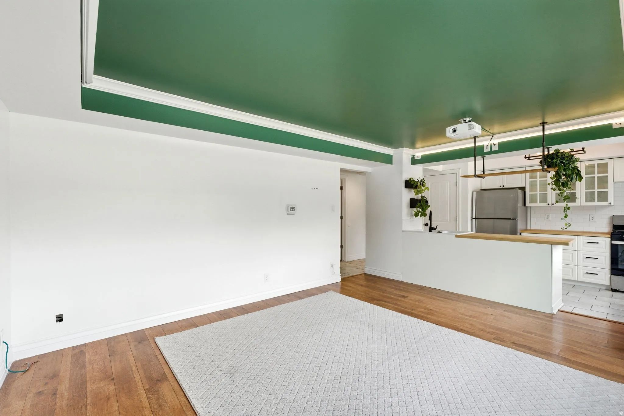 Unfurnished living room featuring light wood-style flooring and baseboards
