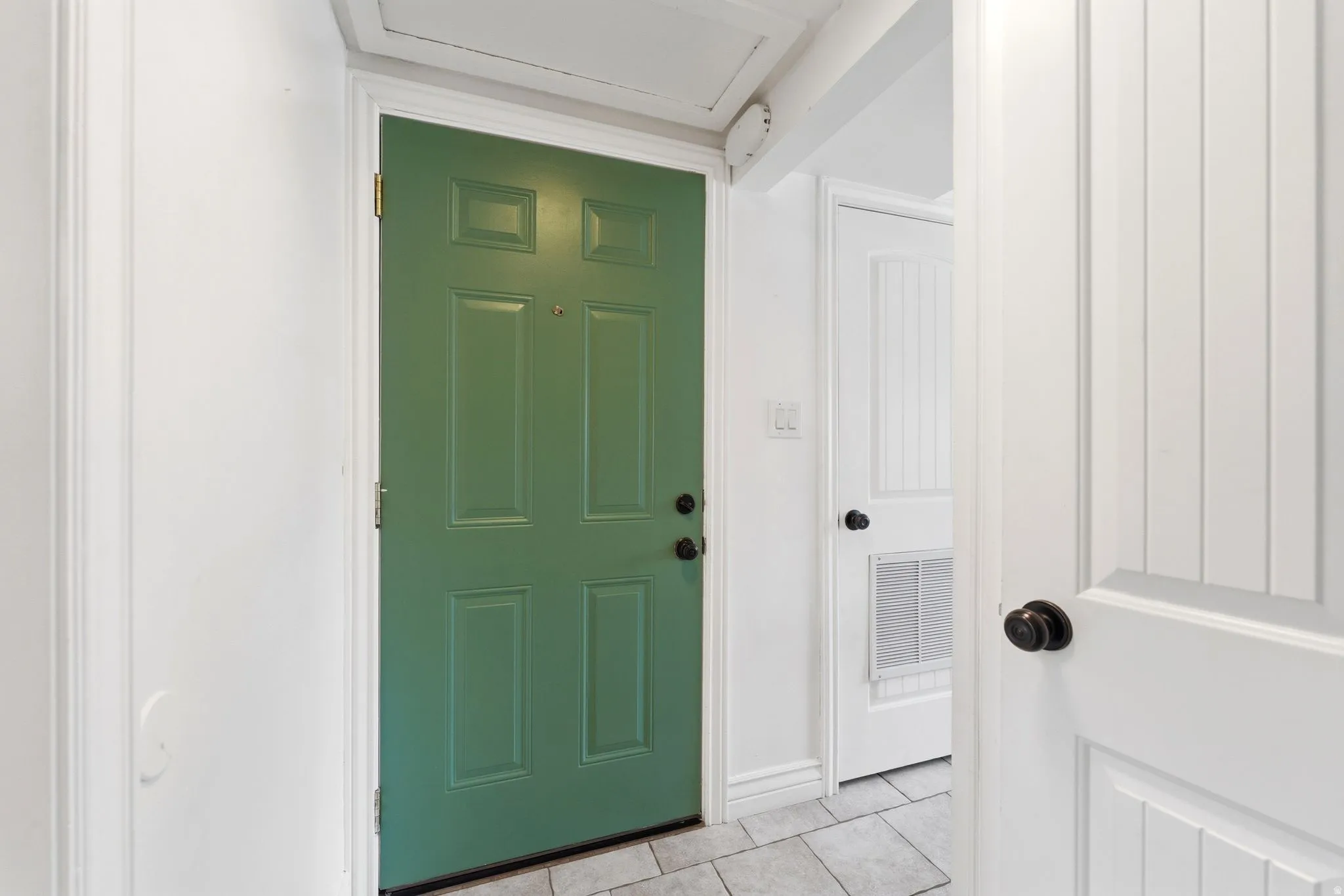 Entryway featuring light tile patterned floors and baseboards