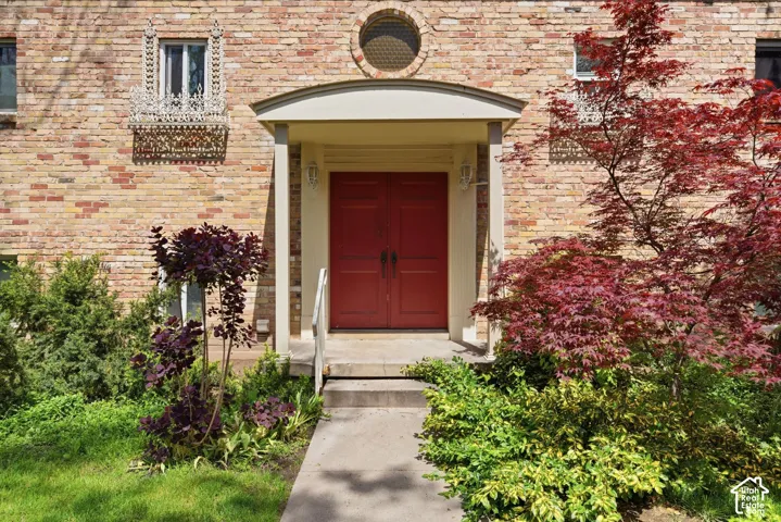 Doorway to property featuring brick siding