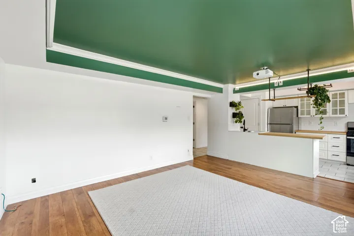 Unfurnished living room featuring light wood-style flooring and baseboards