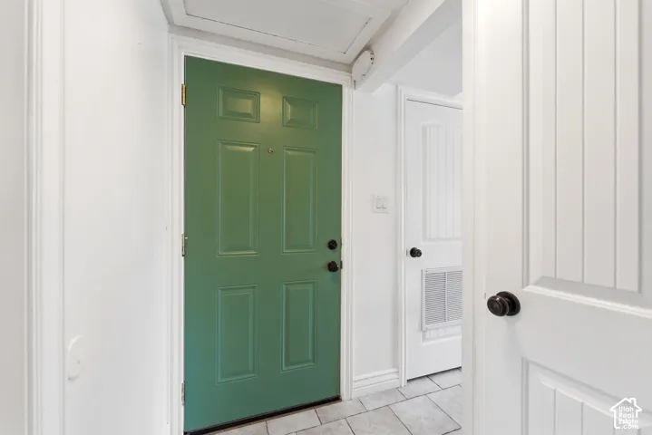 Entryway featuring light tile patterned floors and baseboards