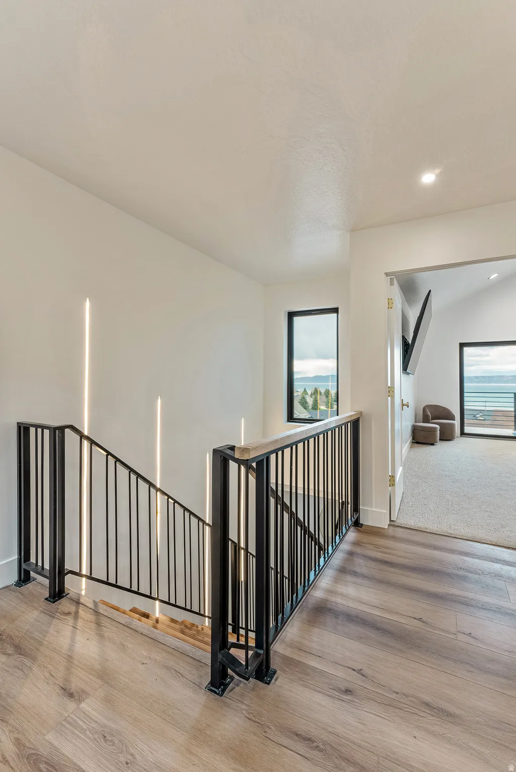 Stairs featuring wood finished floors and recessed lighting