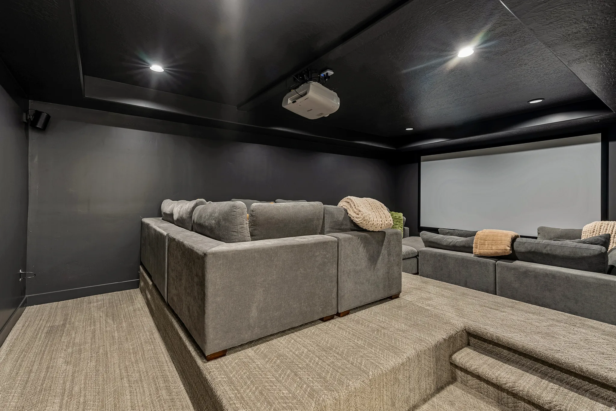 Cinema room featuring a raised ceiling and recessed lighting
