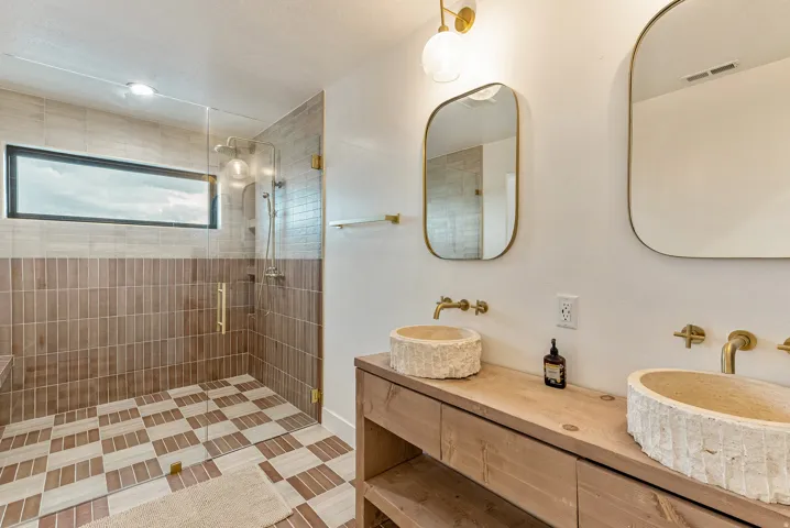 Full bath featuring double vanity and a shower stall