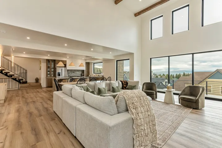 Living room with beam ceiling, light wood finished floors, and recessed lighting