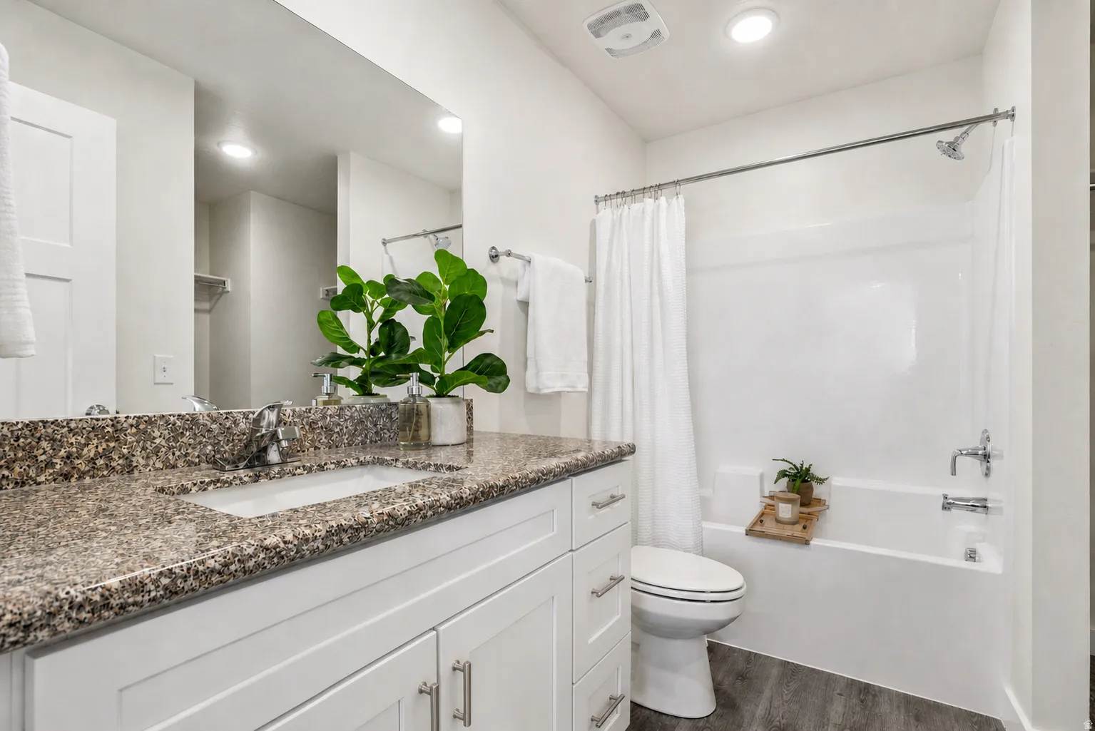 Bathroom with vanity, shower / tub combo, dark wood-type flooring, and recessed lighting
