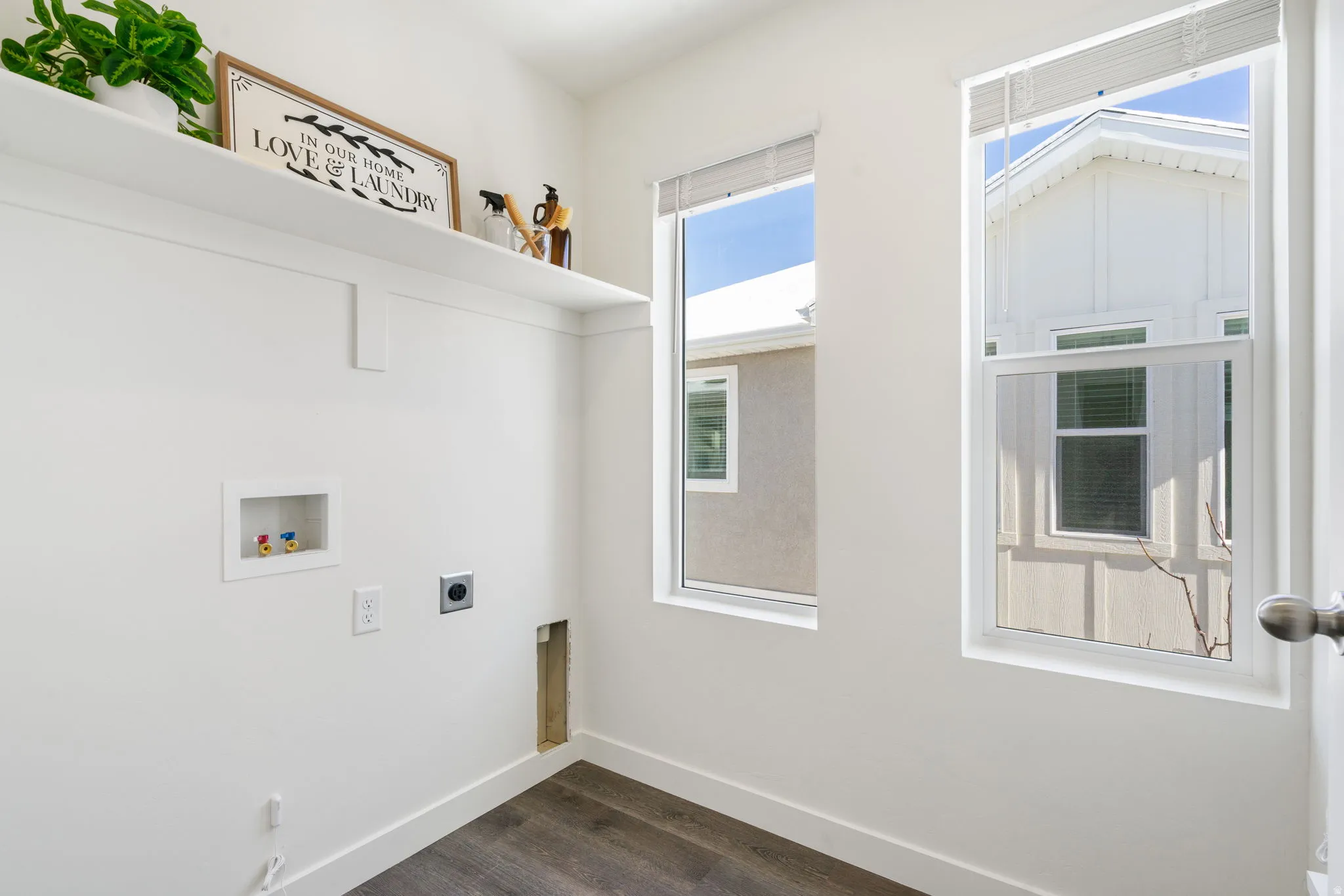 Laundry area with hookup for an electric dryer, hookup for a washing machine, and dark wood-style floors