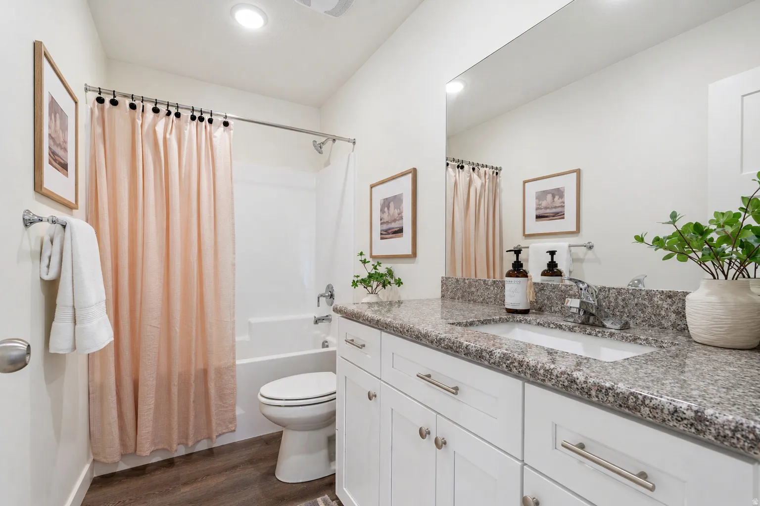 Bathroom with vanity, dark wood-style flooring, shower / bathtub combination with curtain, and recessed lighting