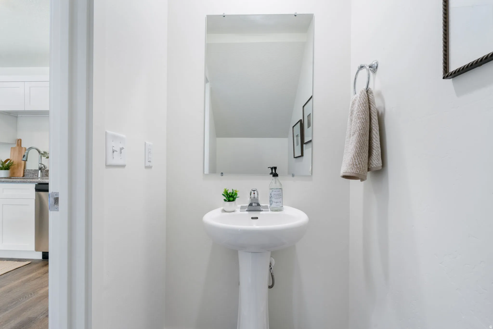 Half bath featuring a sink and wood finished floors