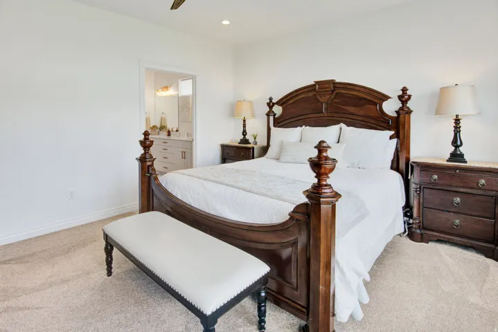 Bedroom featuring light colored carpet, connected bathroom, a ceiling fan, and recessed lighting