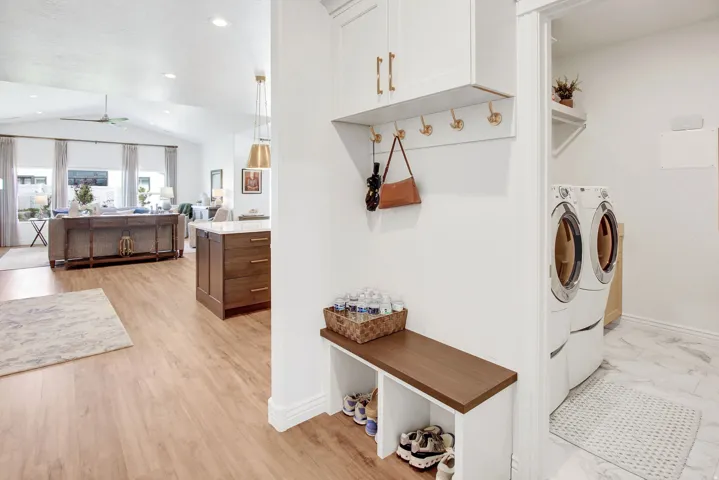 Laundry room with vaulted ceiling, a ceiling fan, washing machine and dryer, and recessed lighting