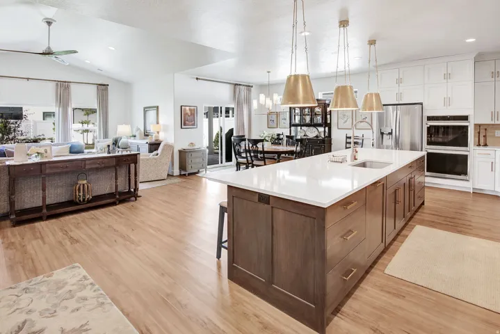 Kitchen with two tone color scheme, a ceiling fan, light wood-style flooring, stainless steel fridge, and multiple ovens