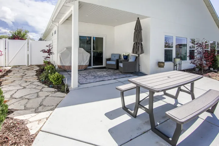 View of patio featuring a gate and area for grilling