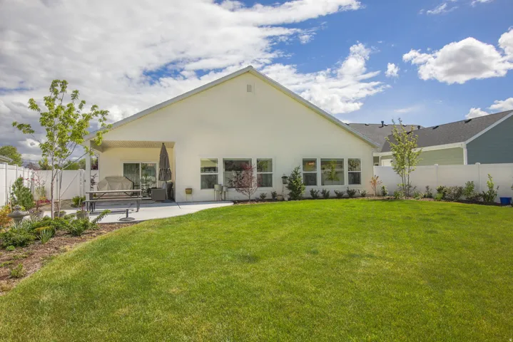 Rear view of property with a fenced backyard, a patio, stucco siding, and a gate