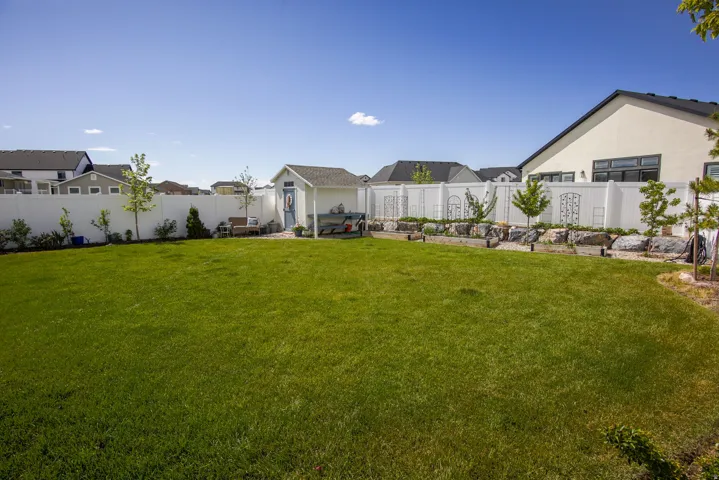Fenced backyard with a residential view and an outbuilding