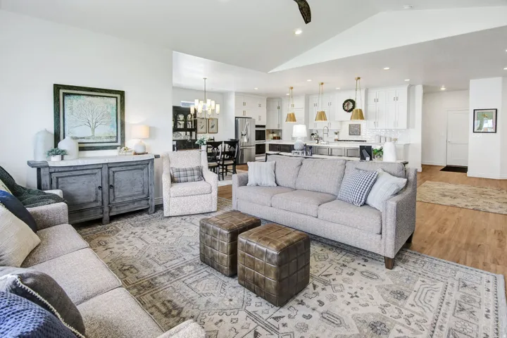 Living area with light wood-style flooring, lofted ceiling, and a chandelier