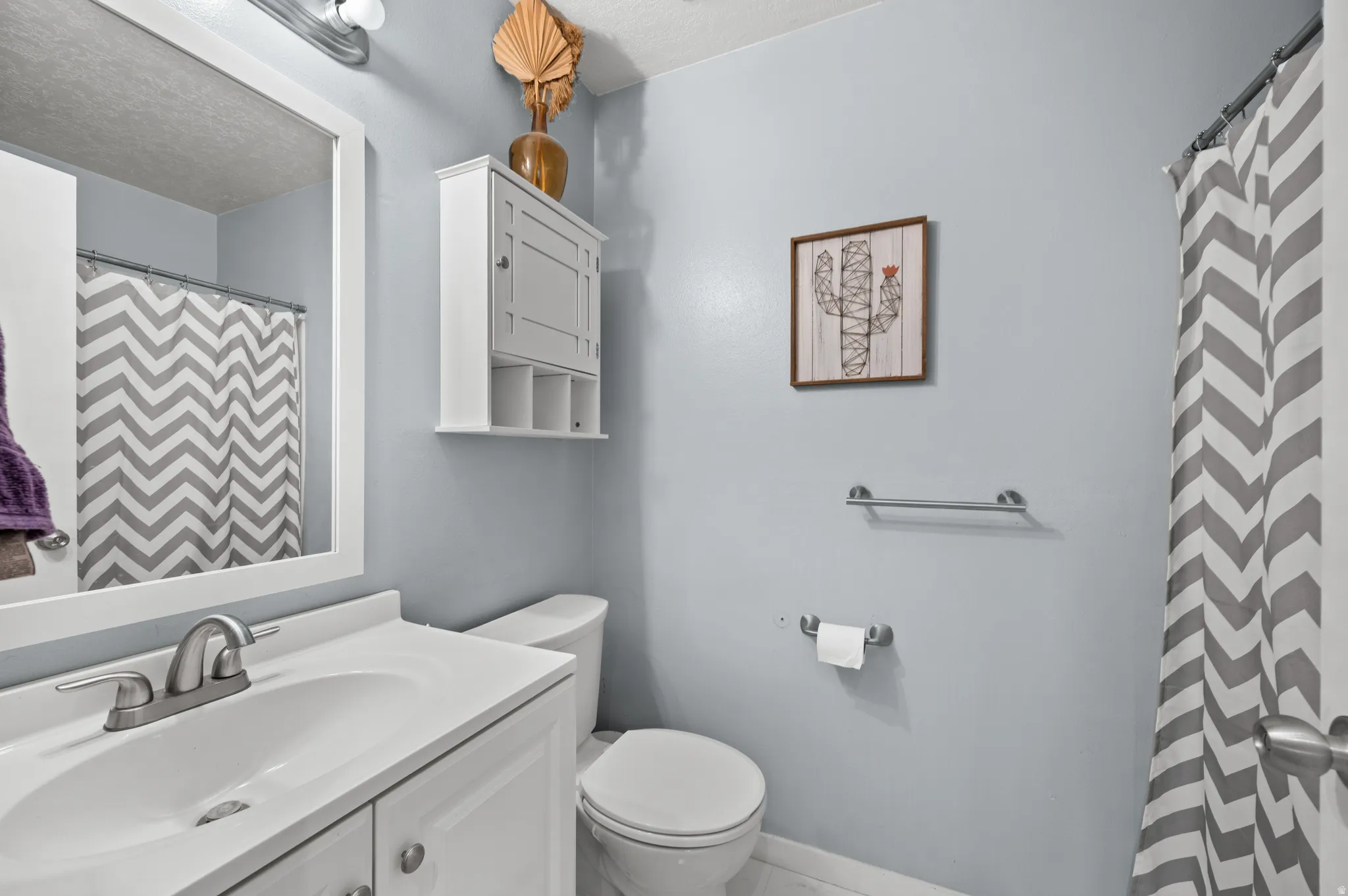 Full bathroom with curtained shower over tub and vanity