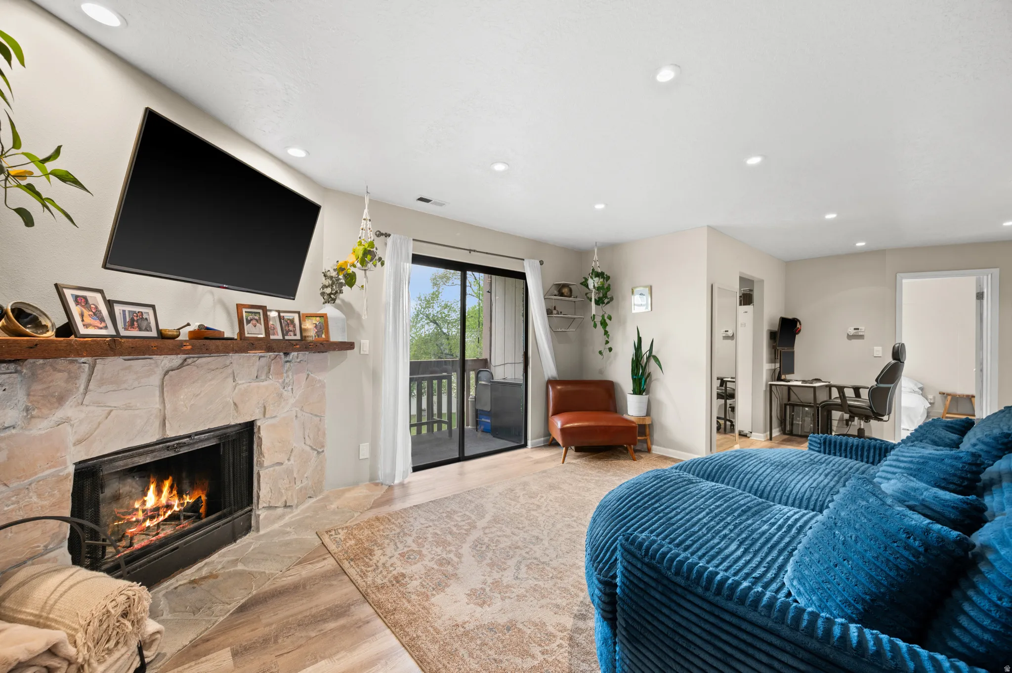 Living area with recessed lighting, light wood finished floors, and a cozy fireplace