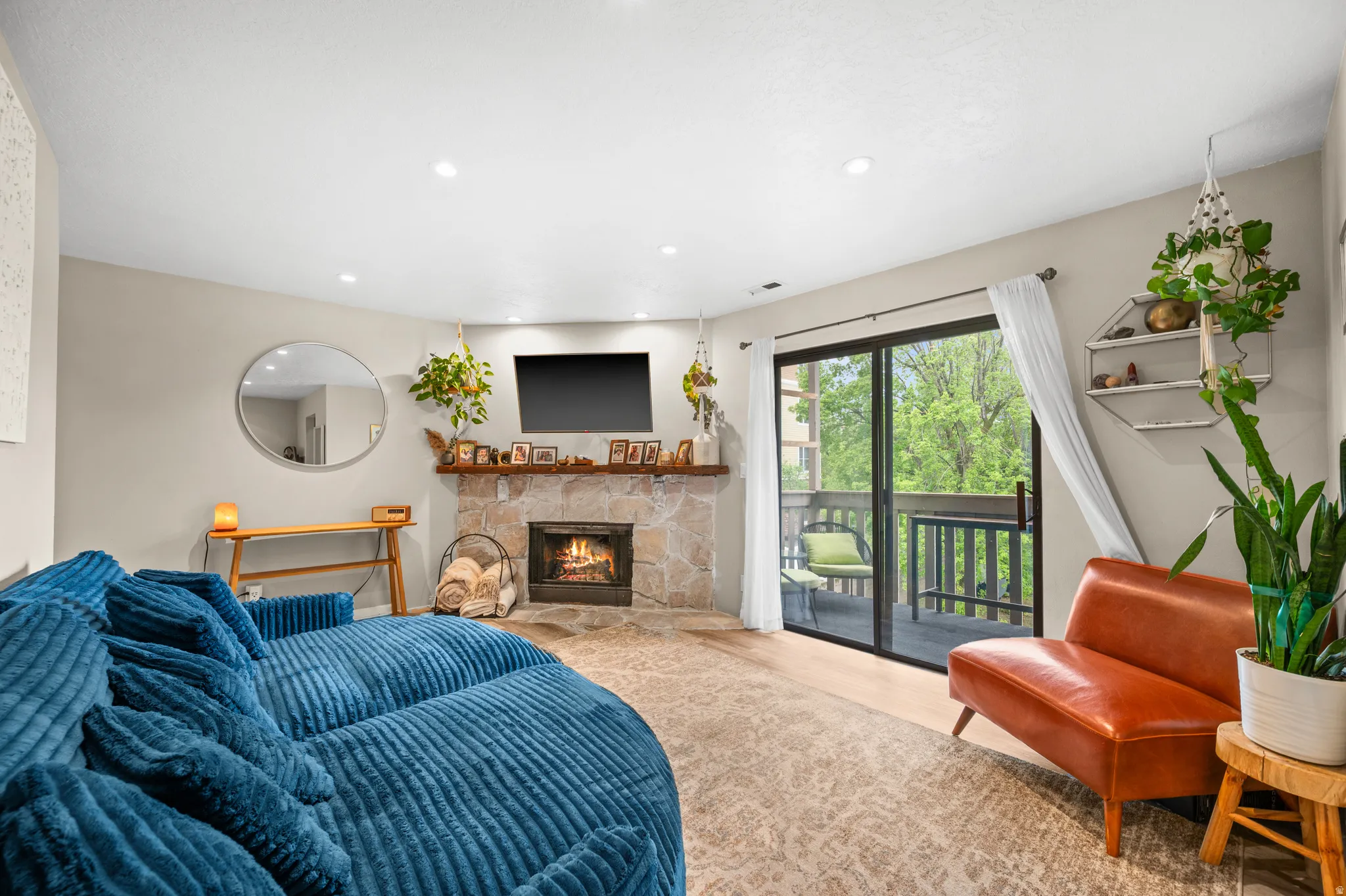 Living room with light vinyl flooring, recessed lighting, and a fireplace