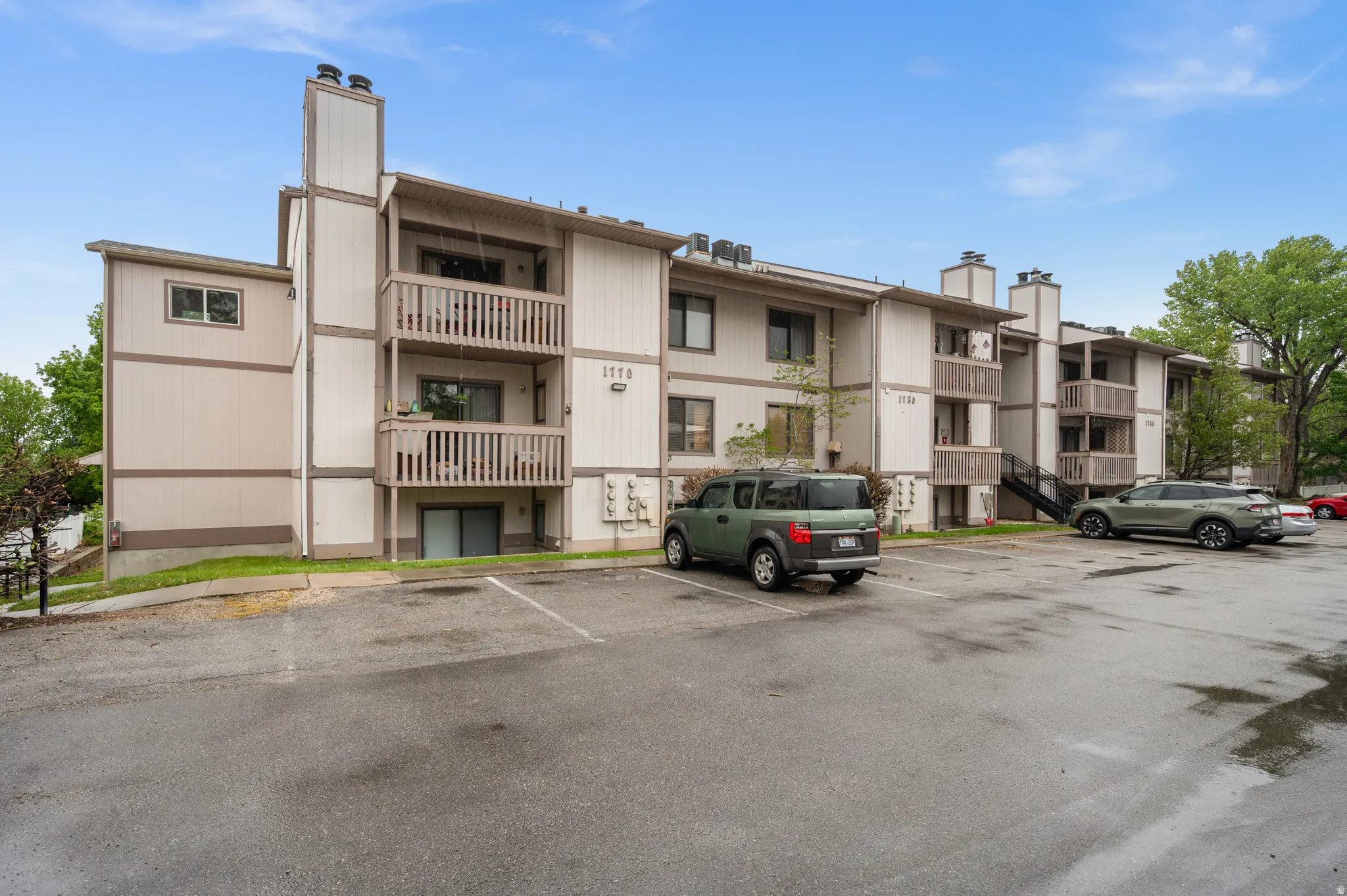 View of apartment building / complex featuring uncovered parking