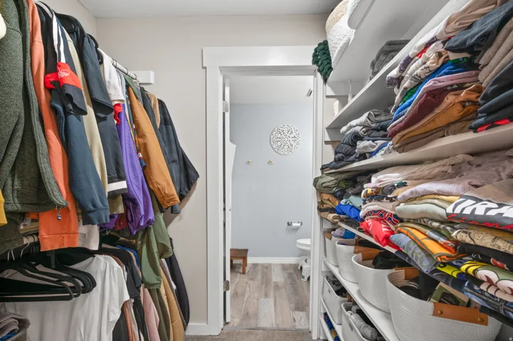 Walk in closet with light wood finished floors