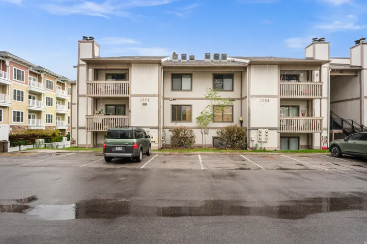 View of apartment building / complex with uncovered parking