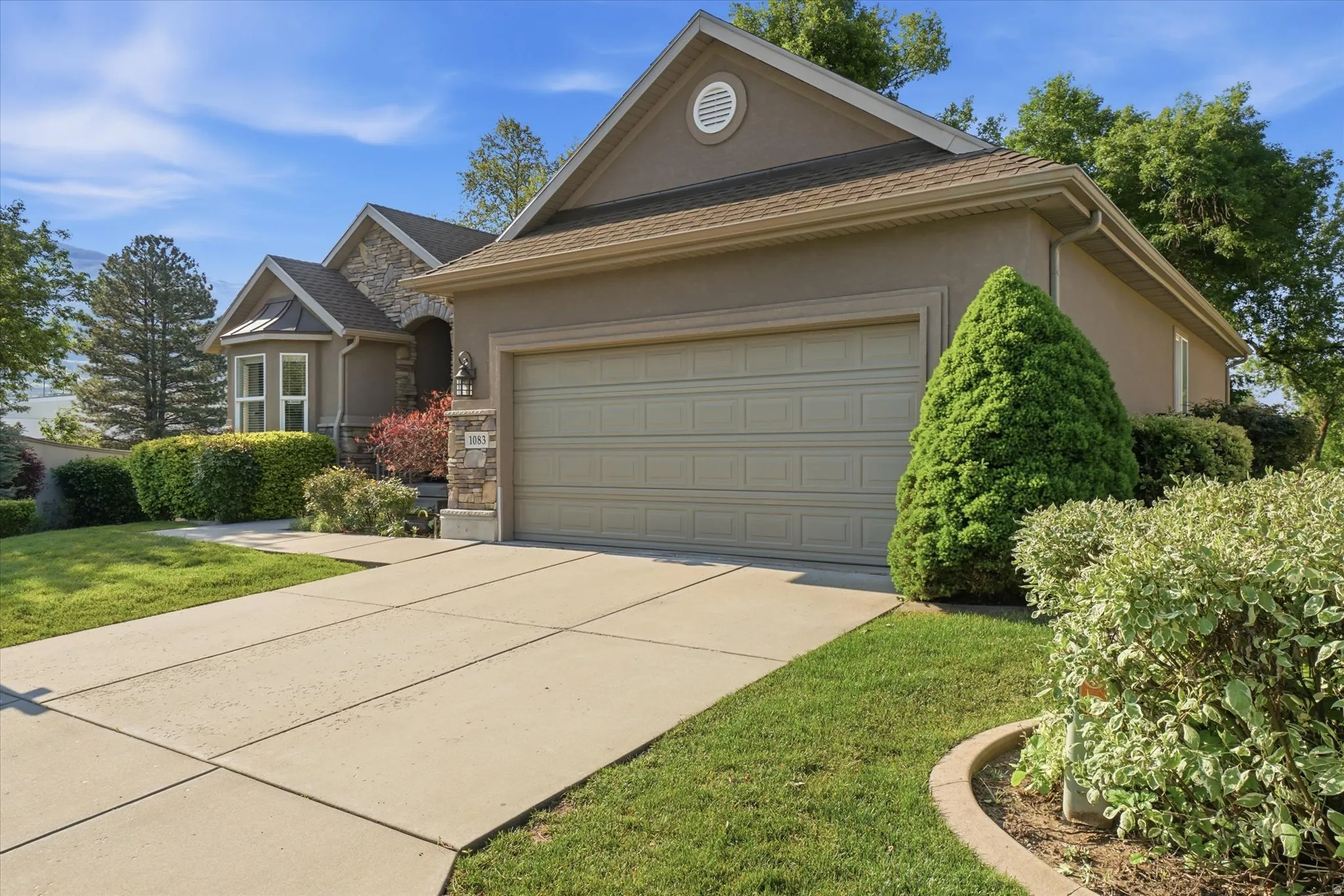 Stucco and stone facade with an integrated two-car garage