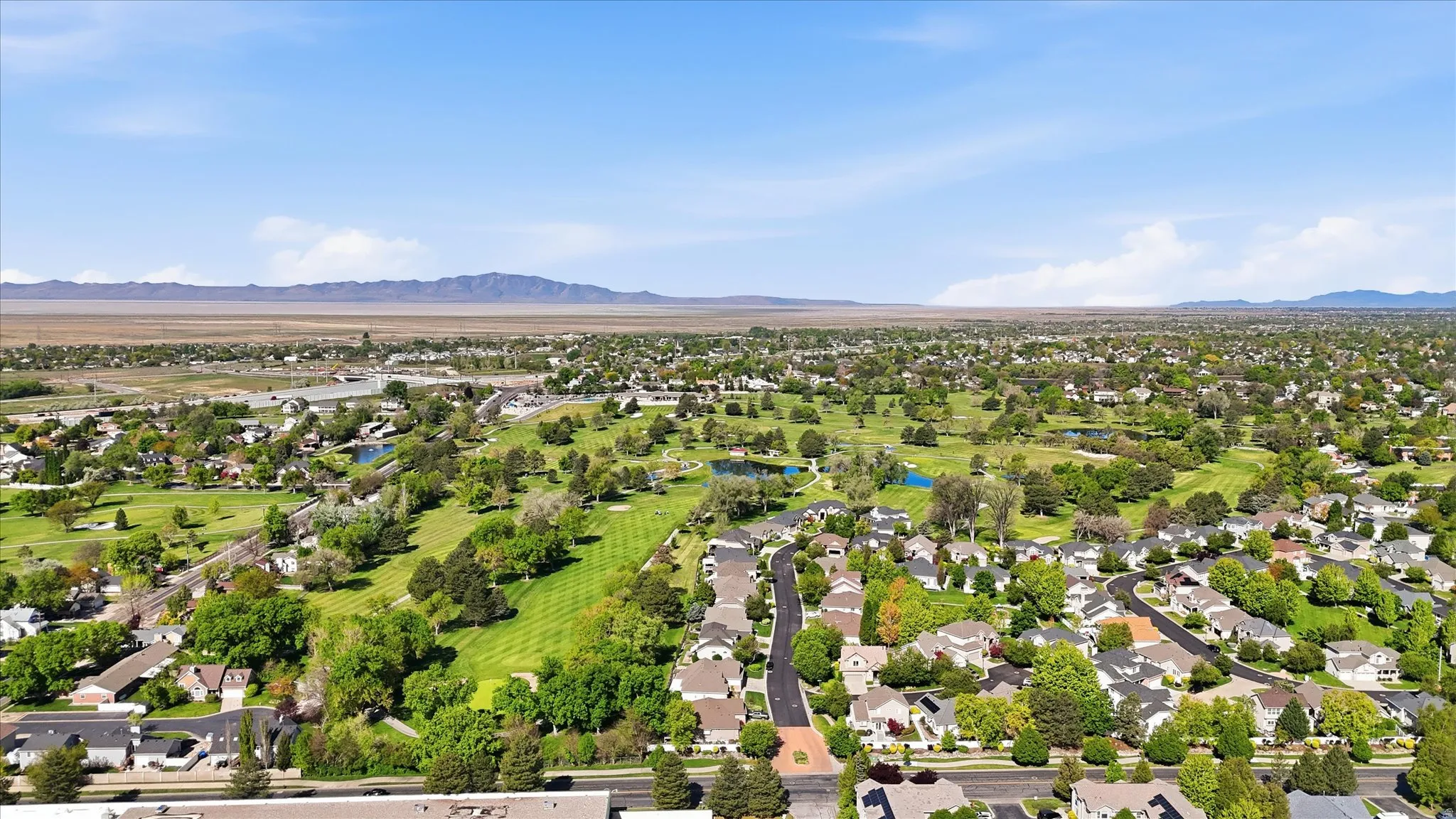 Aerial view of residential area featuring a local golf course and a water and mountain view