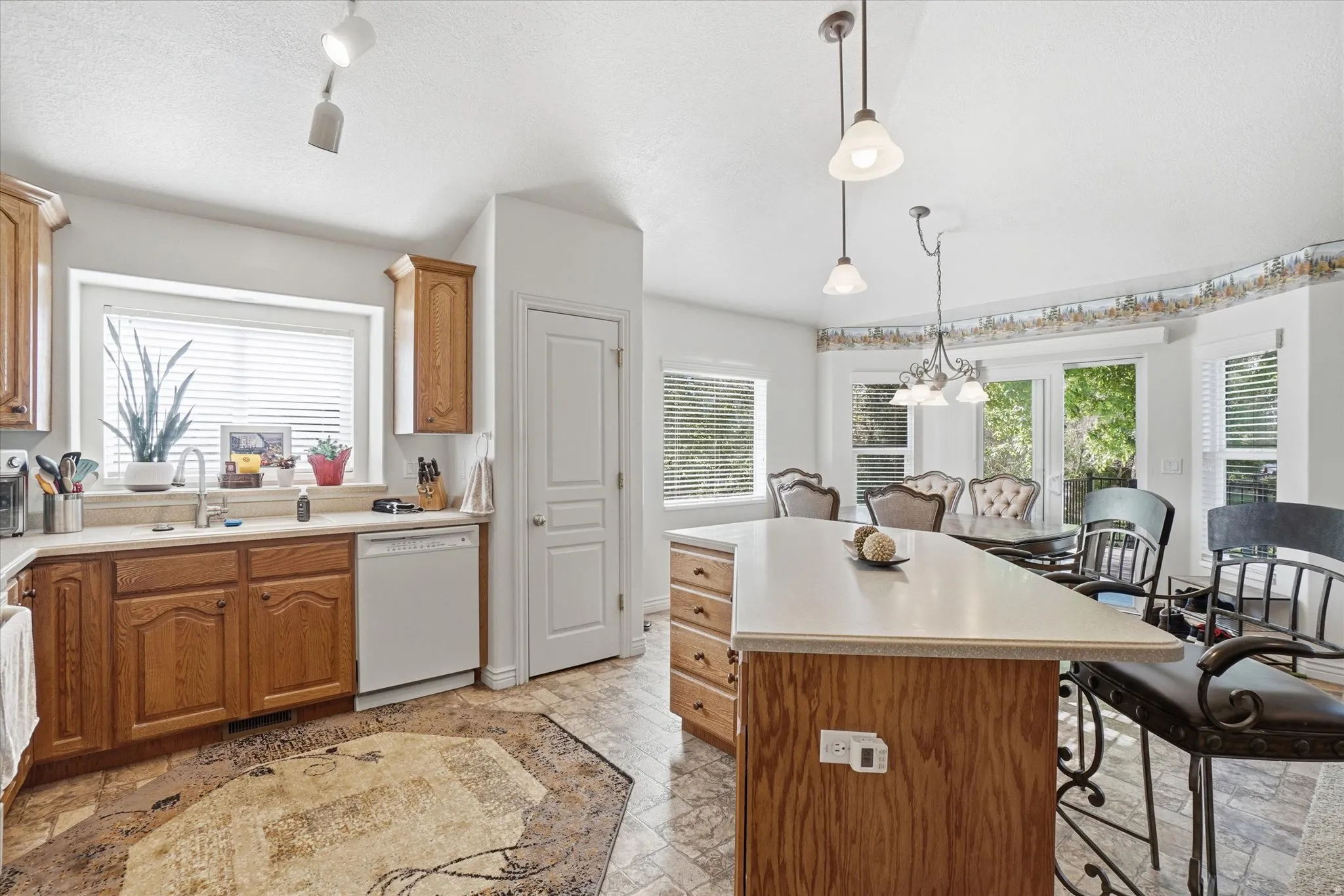 Kitchen with wood-finish cabinetry, light countertops, and a white sink