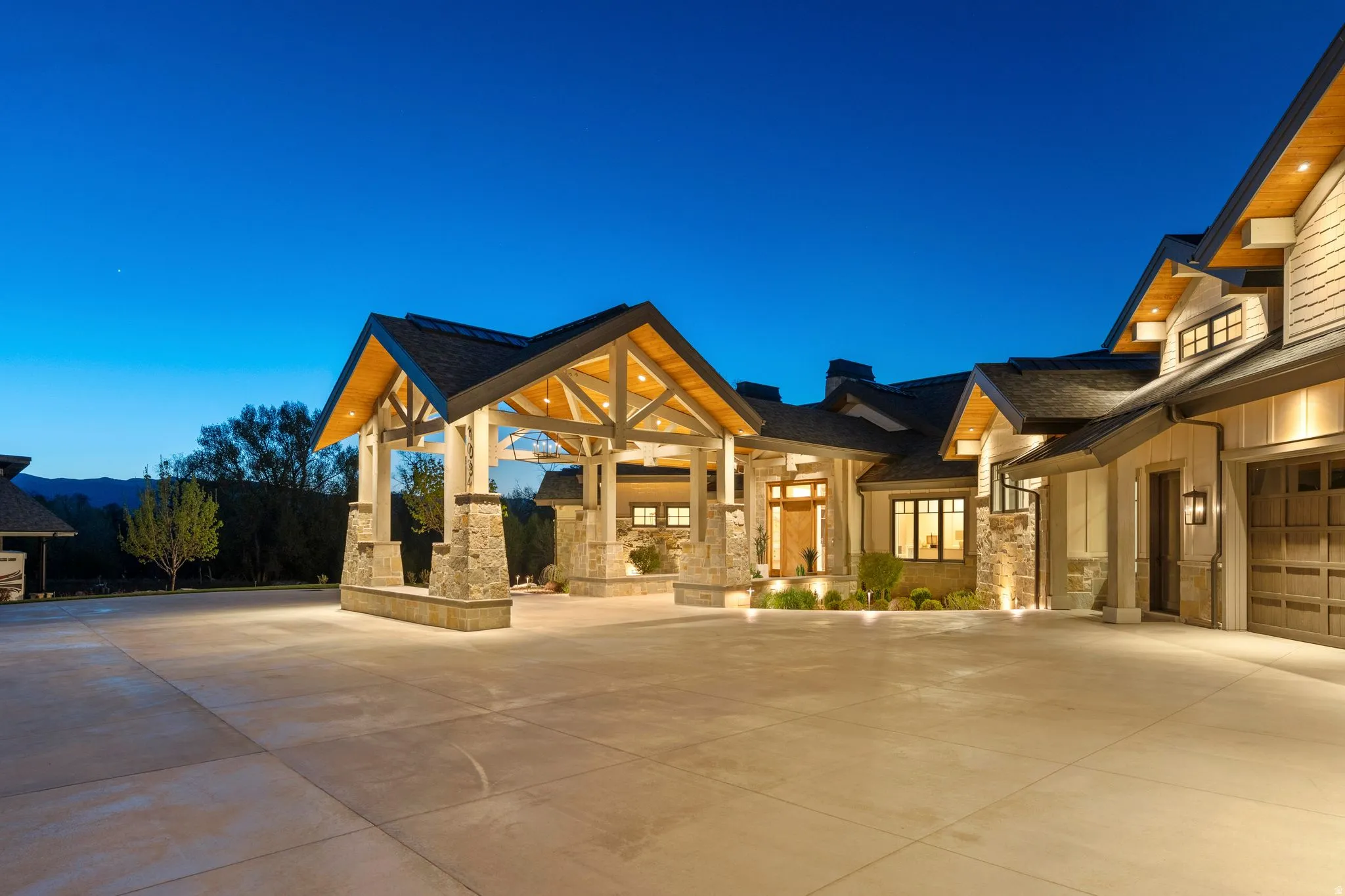 View of front of house featuring stone siding, a garage, and concrete driveway