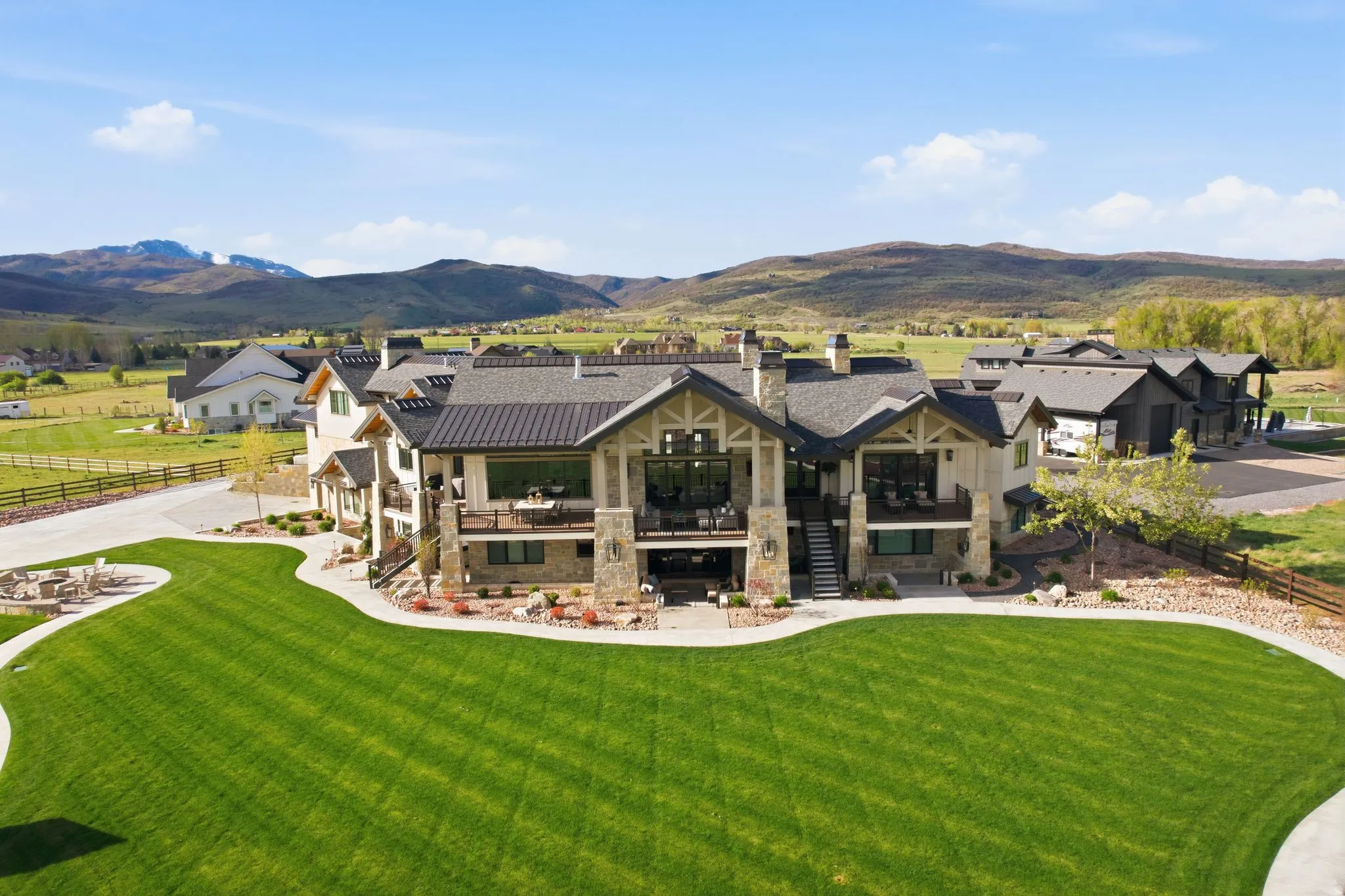Back of house featuring a chimney, a mountain view, stone siding, and covered porch