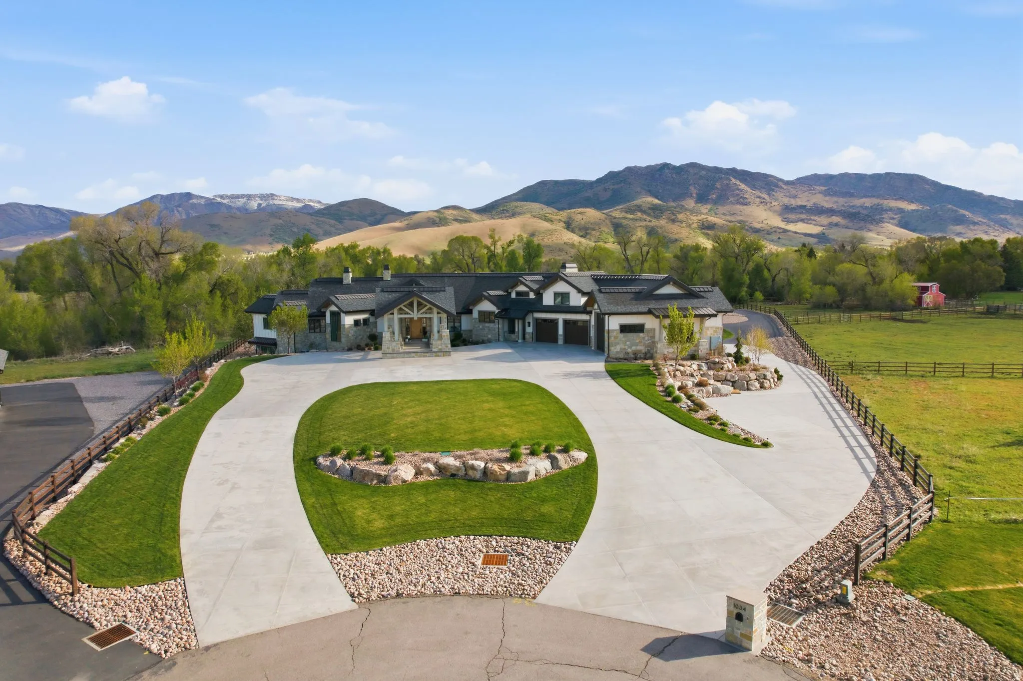 View of front of property with a mountain view, curved driveway, and stone siding