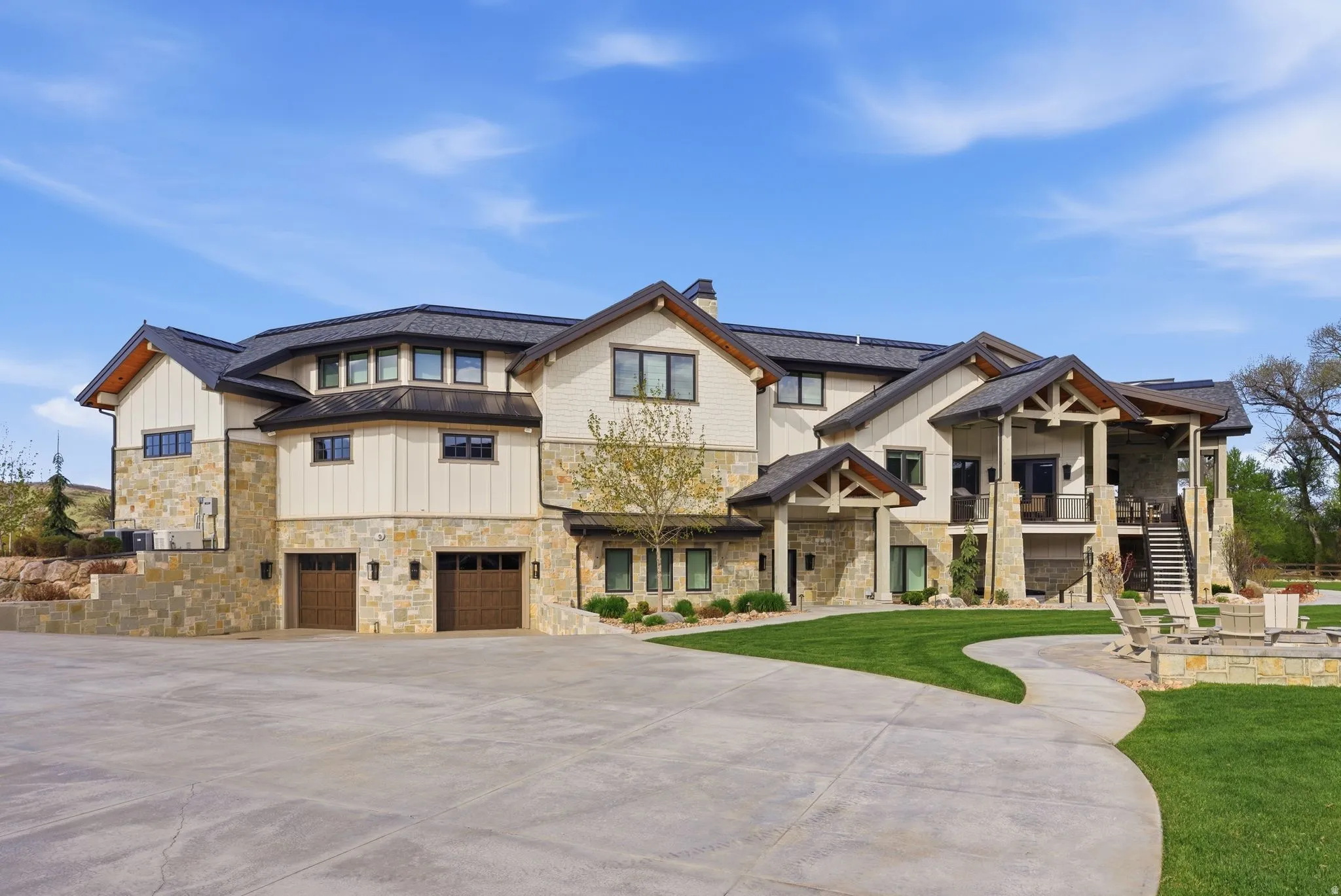 Craftsman inspired home featuring stone siding, an attached garage, concrete driveway, and a standing seam roof