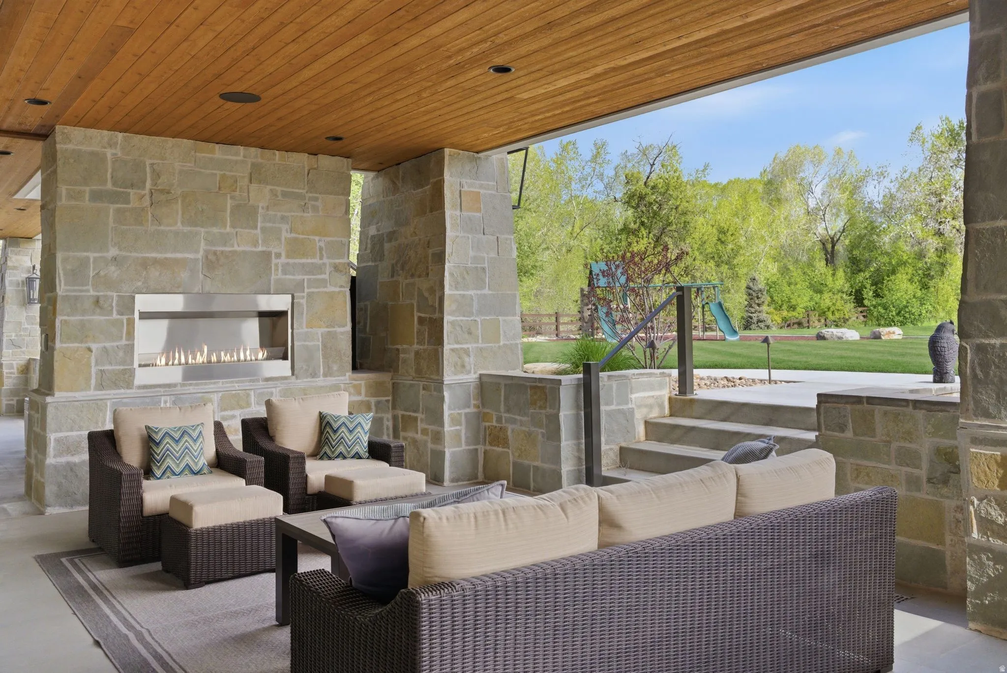 View of patio with an outdoor living space with a fireplace and a playground