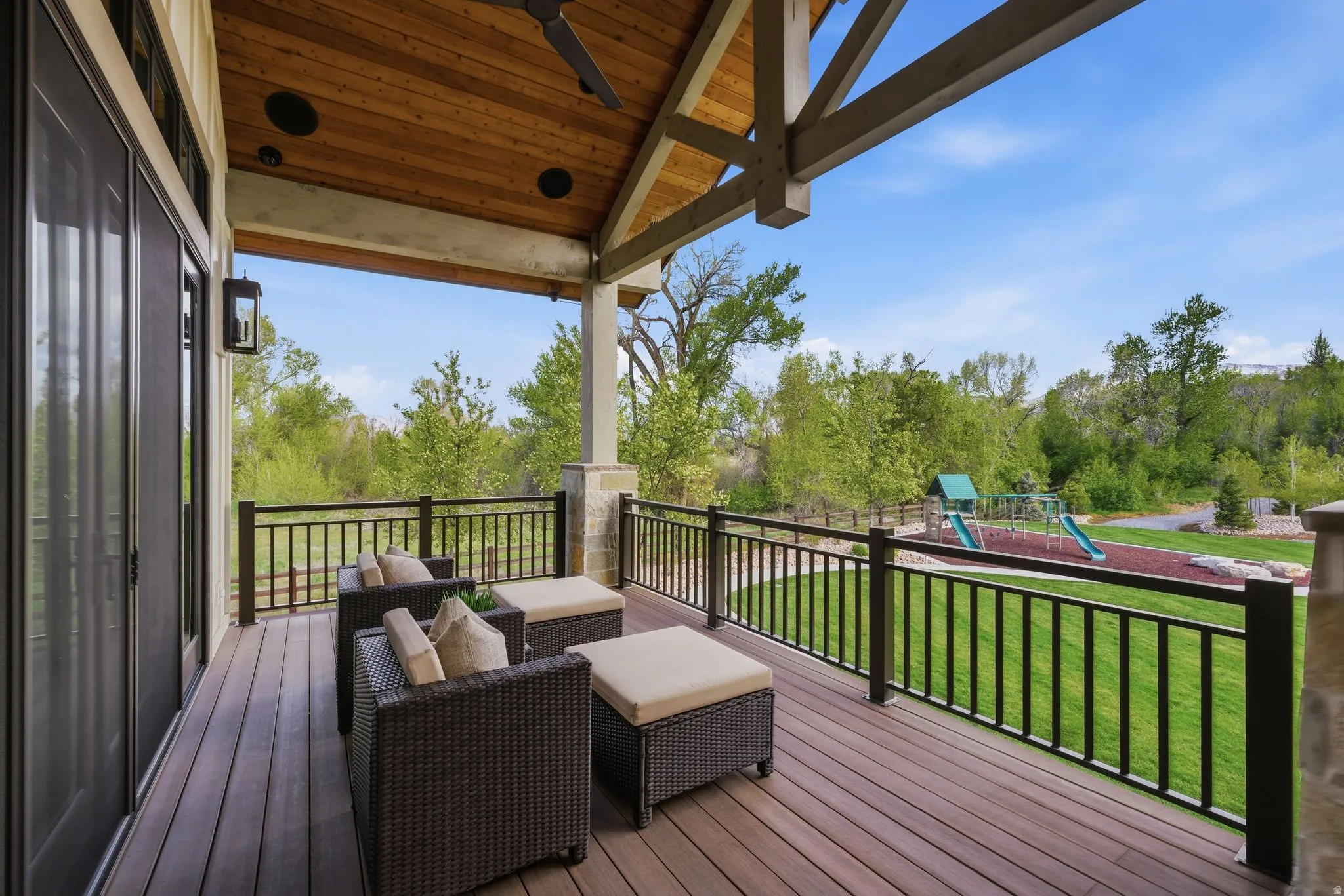 Wooden deck featuring outdoor furniture, a yard, ceiling fan, and a playground