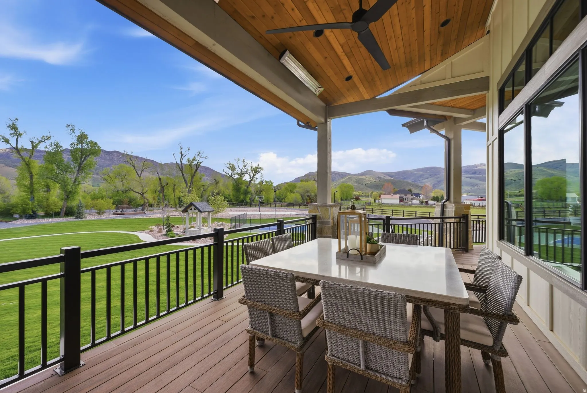 Wooden terrace with a lawn, a mountain view, ceiling fan, and outdoor dining area