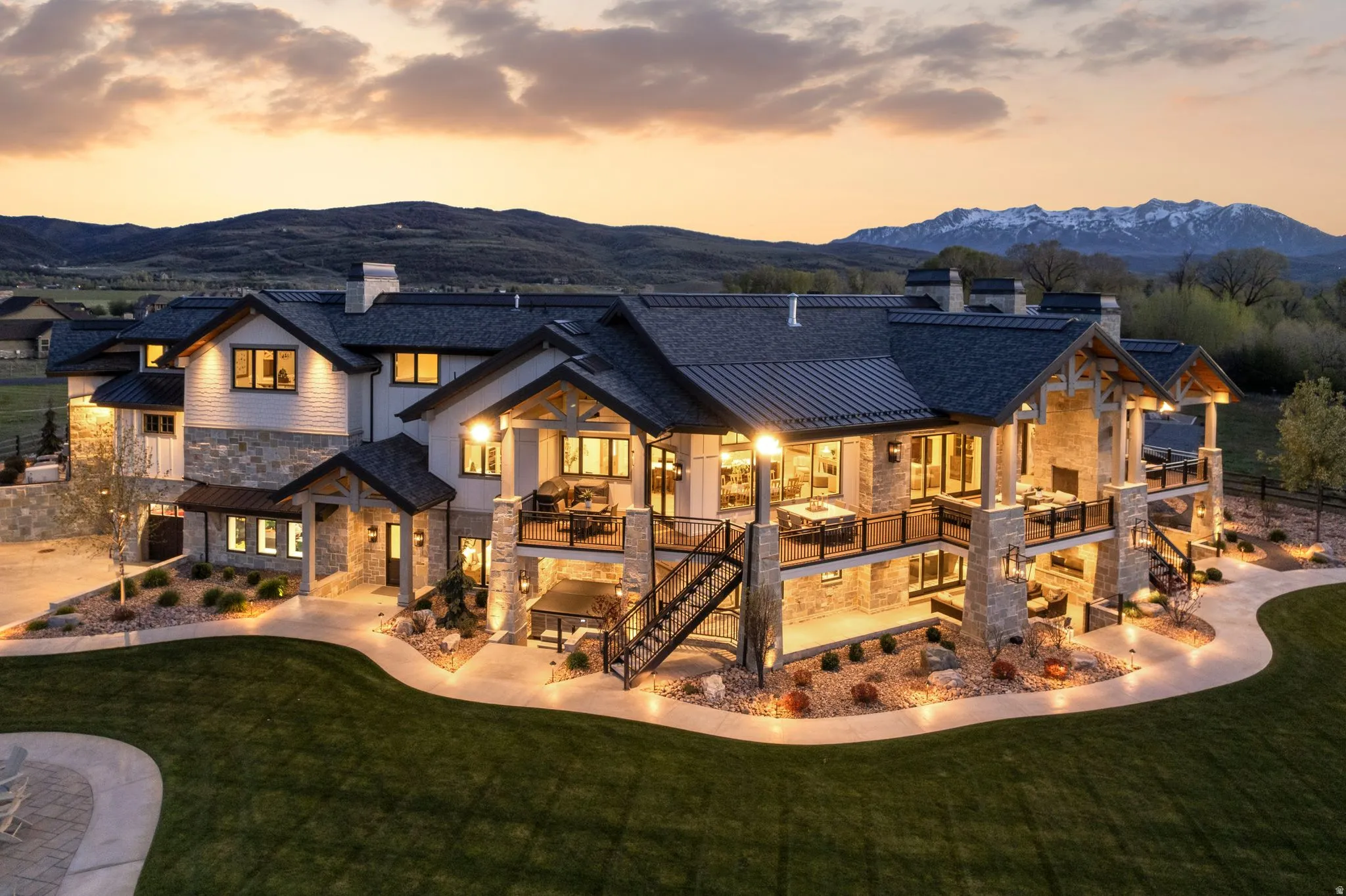 Rear view of property featuring a chimney, stone siding, a yard, and a mountain view