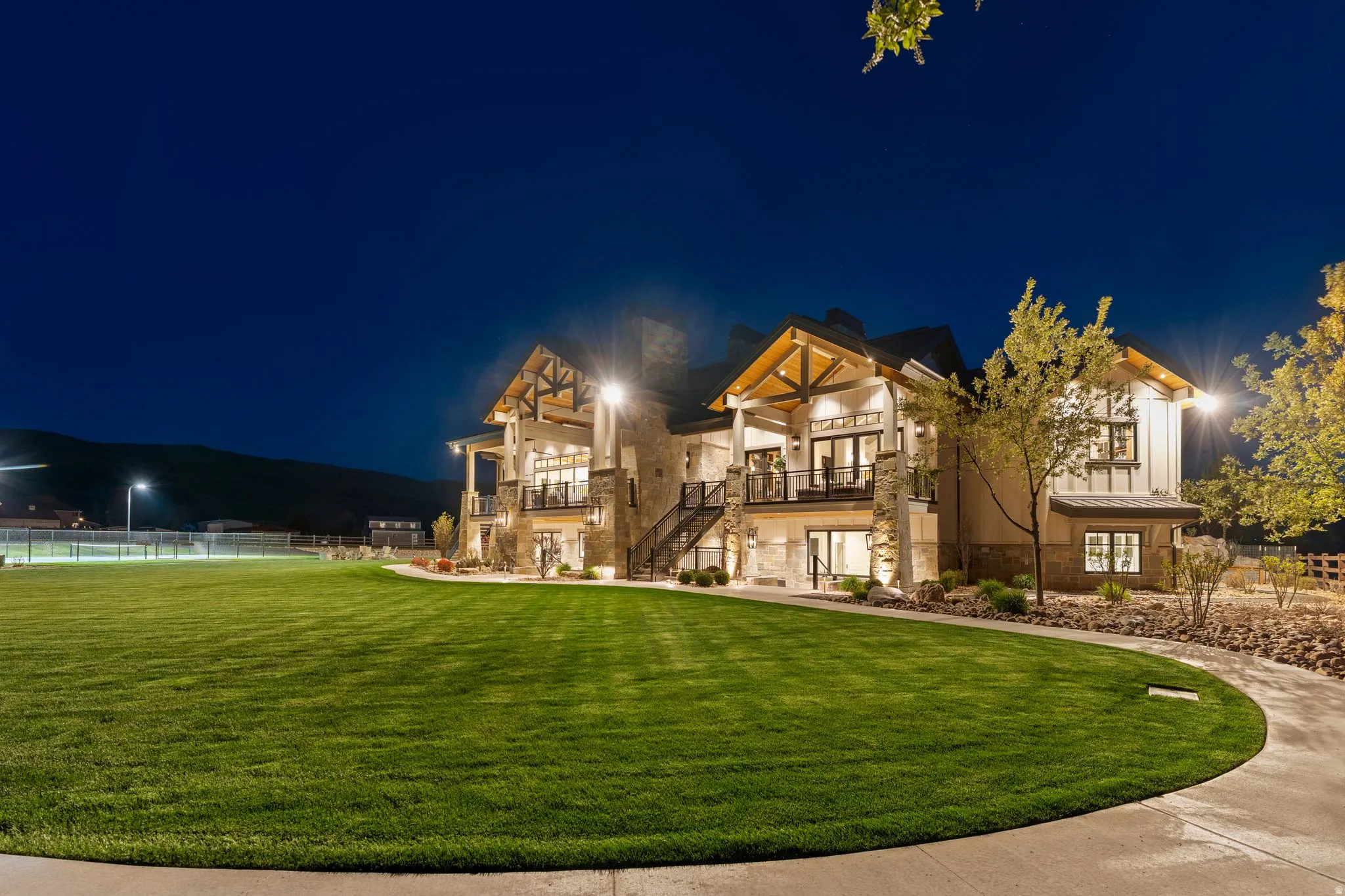 Back of house at night with stone siding and stucco siding