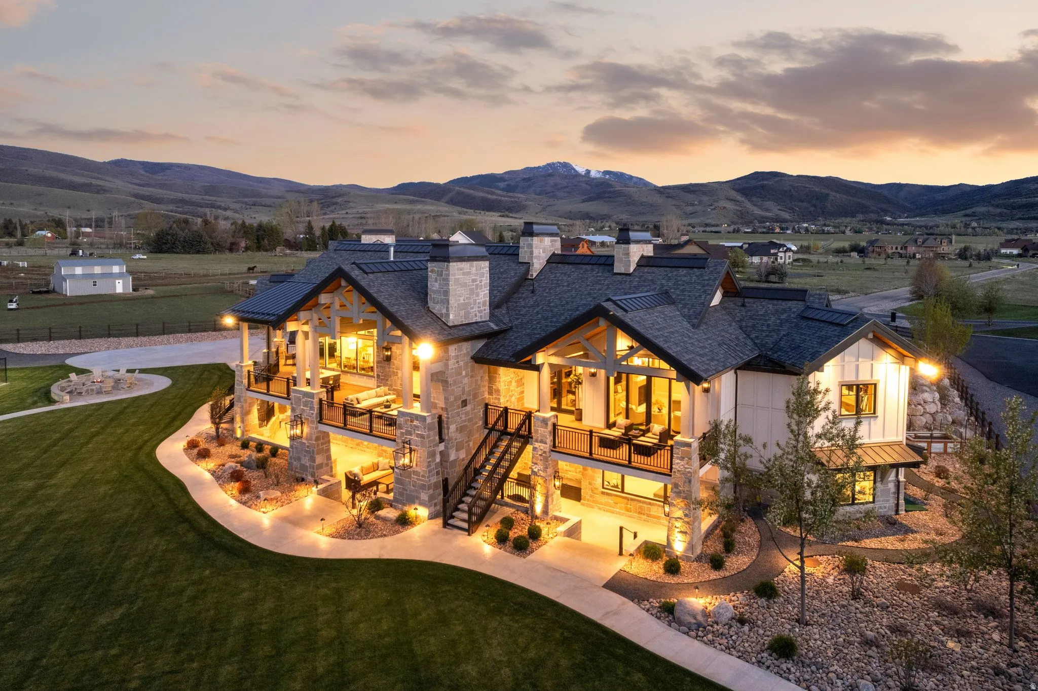 Rear view of house featuring a standing seam roof, a chimney, a balcony, and a mountain view