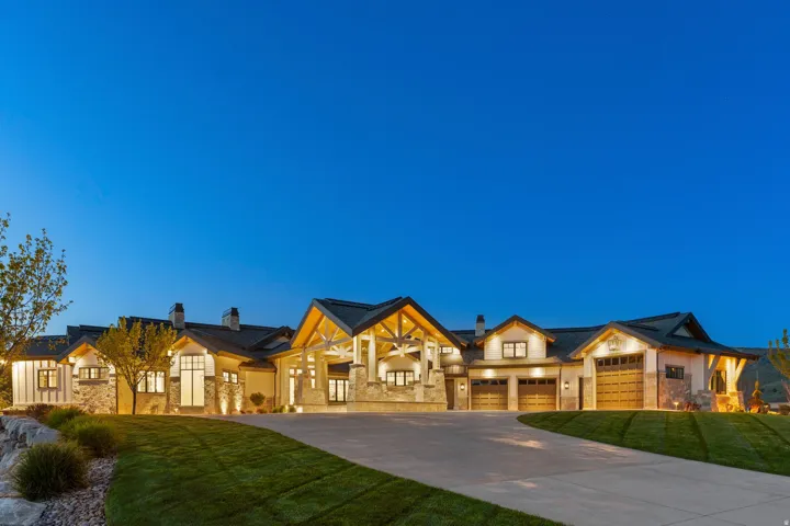 View of front of property with a chimney, concrete driveway, a front yard, and stone siding
